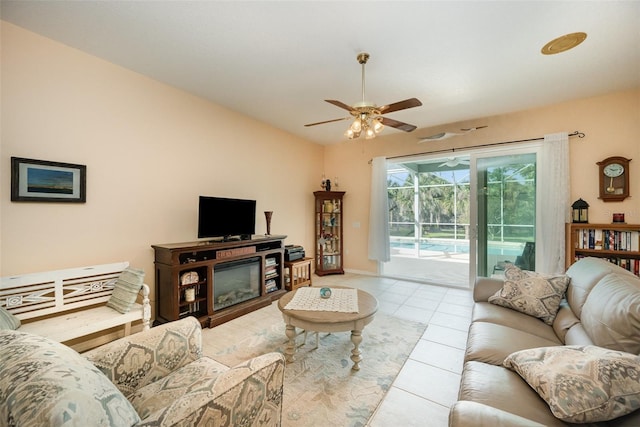 living area featuring vaulted ceiling, a sunroom, a ceiling fan, and tile patterned floors