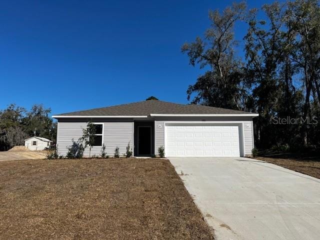 single story home with a garage, a front lawn, and concrete driveway