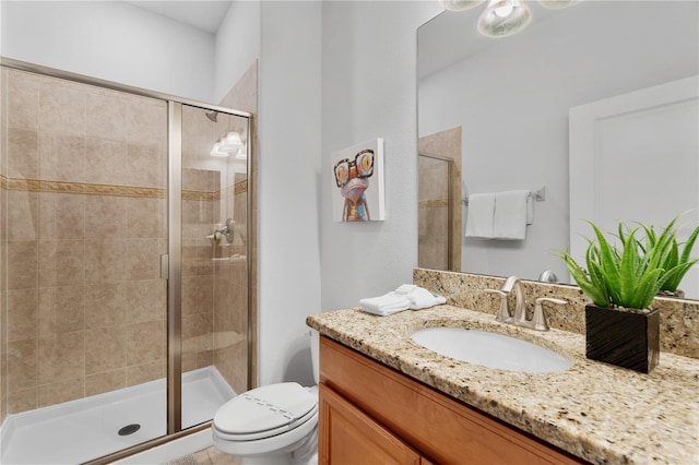 bathroom featuring a shower stall, toilet, and vanity