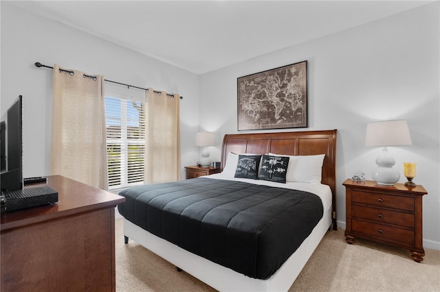 bedroom featuring light carpet and baseboards