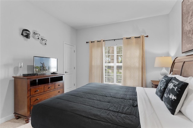 bedroom featuring baseboards and light colored carpet