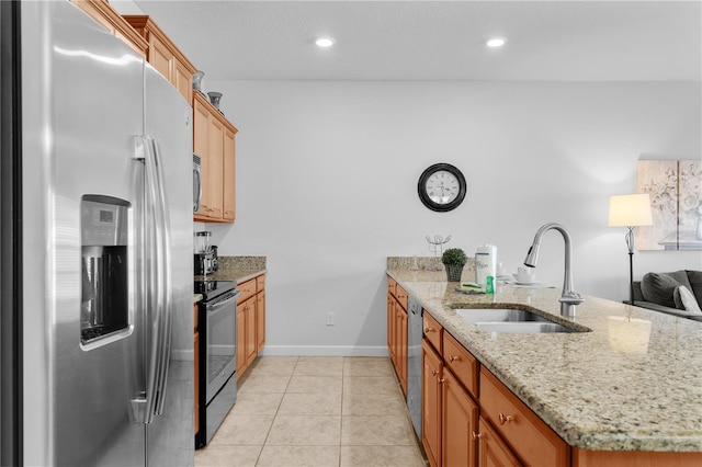 kitchen with light stone counters, recessed lighting, appliances with stainless steel finishes, light tile patterned flooring, and a sink