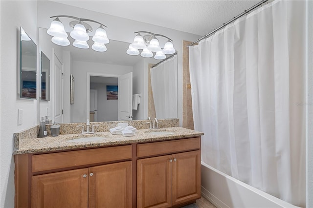 full bathroom with a textured ceiling, double vanity, a sink, and shower / tub combo with curtain