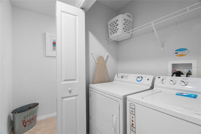 washroom with light carpet, laundry area, washing machine and dryer, and baseboards