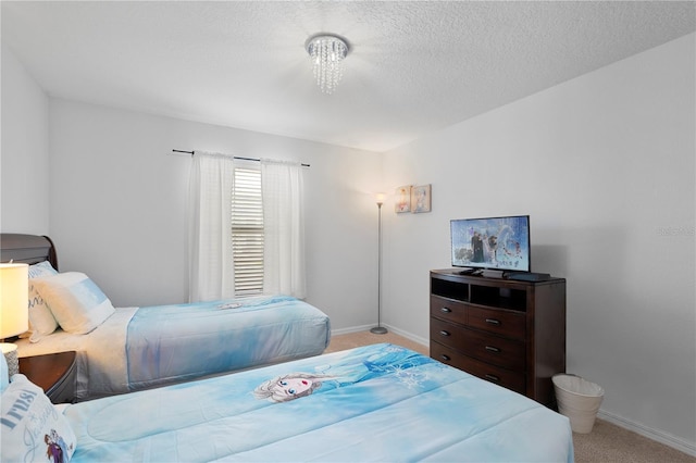 bedroom with baseboards, a textured ceiling, and light colored carpet