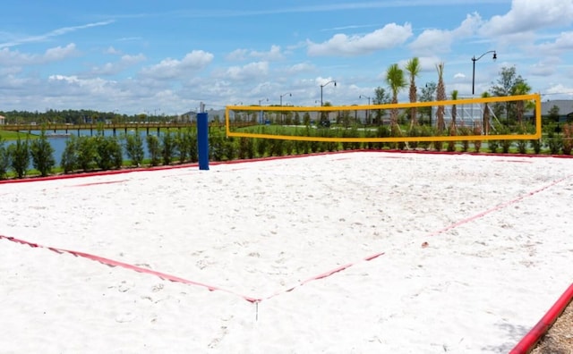 surrounding community featuring volleyball court and a water view