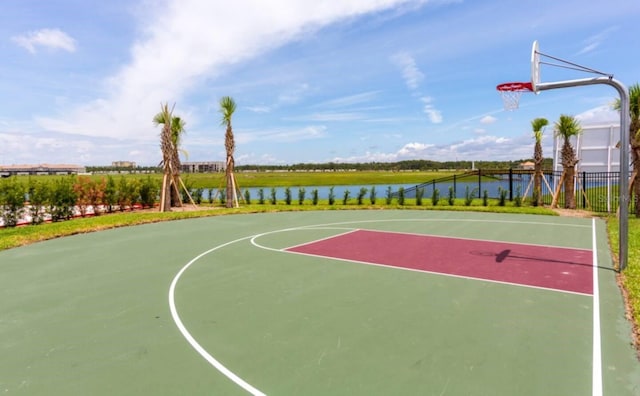 view of sport court featuring community basketball court, a water view, and fence