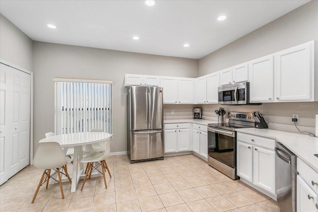 kitchen with light tile patterned floors, stainless steel appliances, light countertops, and white cabinetry