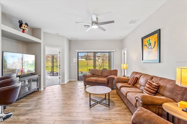 living room featuring visible vents, ceiling fan, light wood-style flooring, and baseboards