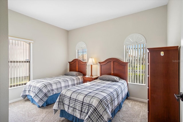 bedroom with light carpet and baseboards