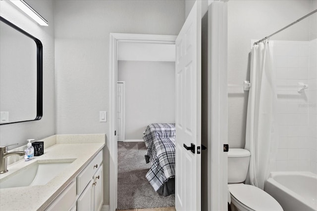 ensuite bathroom featuring connected bathroom, vanity, toilet, and shower / bath combo with shower curtain