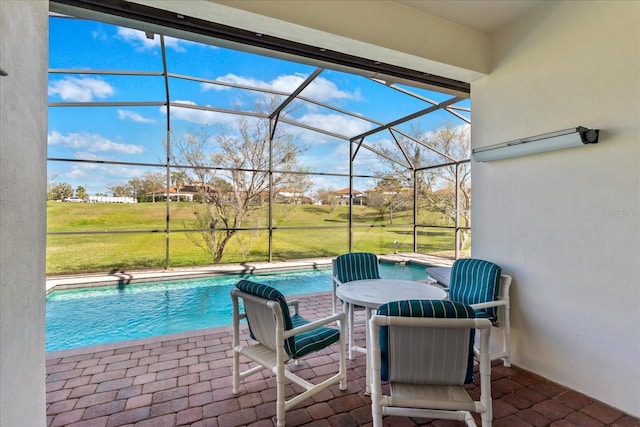 outdoor pool with a yard, a patio area, and a lanai