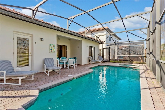 view of pool featuring a lanai, a patio area, and a pool with connected hot tub