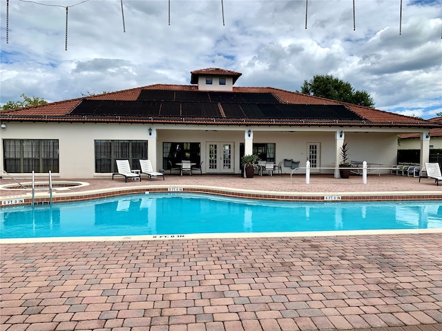 community pool featuring a community hot tub, a patio, and french doors