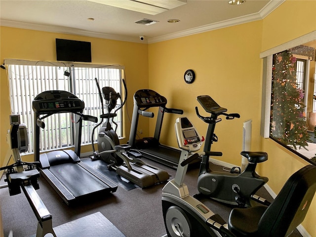 gym with ornamental molding, visible vents, and baseboards