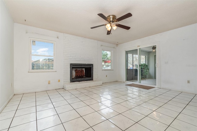 unfurnished living room featuring light tile patterned floors, ceiling fan, a textured ceiling, and a brick fireplace