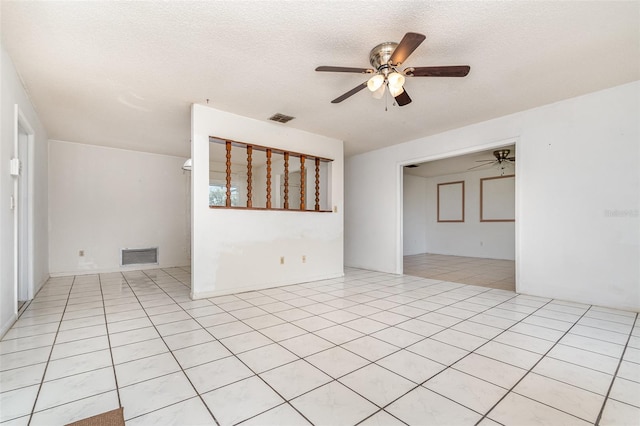 empty room with light tile patterned floors, ceiling fan, a textured ceiling, and visible vents