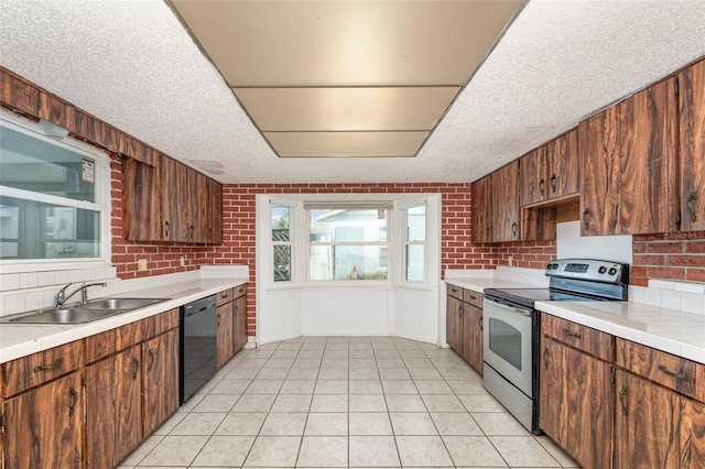 kitchen featuring black dishwasher, light tile patterned floors, light countertops, a sink, and stainless steel electric range