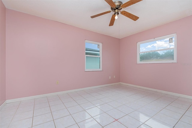 unfurnished room featuring a ceiling fan, a wealth of natural light, and baseboards