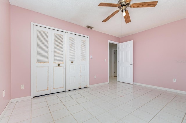 unfurnished bedroom featuring light tile patterned floors, ceiling fan, visible vents, baseboards, and a closet