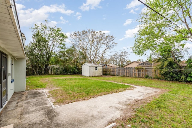 view of yard featuring a shed, a patio, a fenced backyard, and an outdoor structure