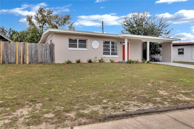 single story home with concrete driveway, an attached carport, a front lawn, and fence