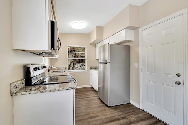 kitchen with white cabinetry, appliances with stainless steel finishes, light stone counters, and dark wood-style flooring