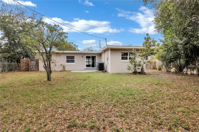 rear view of house featuring a lawn, a patio area, fence, and central air condition unit