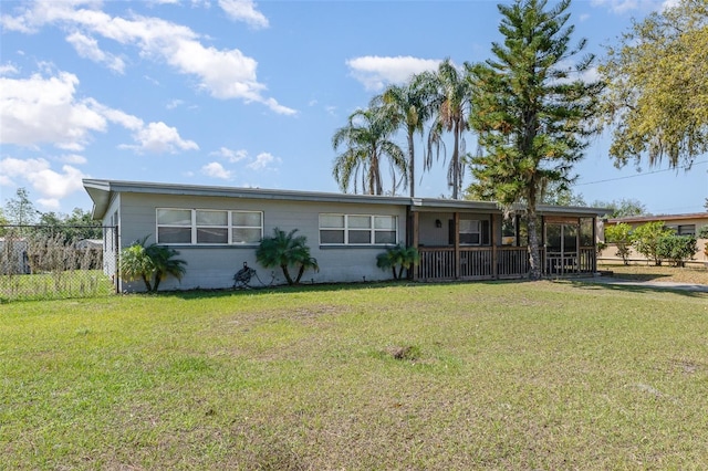 ranch-style home with concrete block siding, fence, and a front lawn