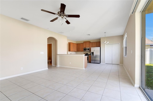 kitchen with arched walkways, visible vents, open floor plan, light countertops, and appliances with stainless steel finishes