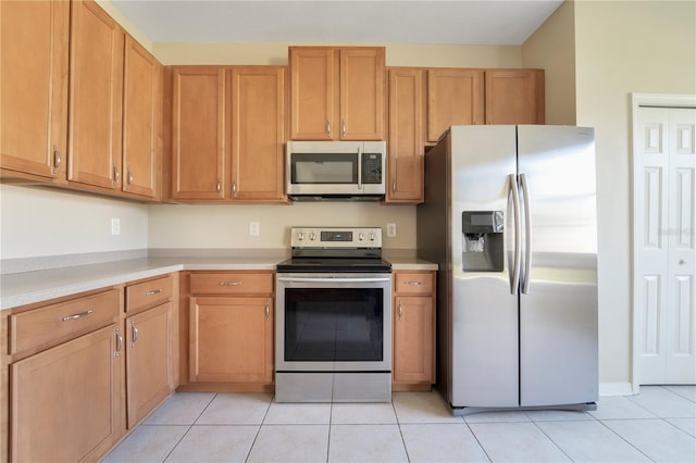 kitchen with appliances with stainless steel finishes, light countertops, and light tile patterned floors