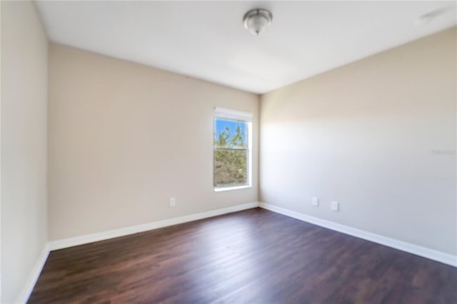 unfurnished room with dark wood finished floors and baseboards