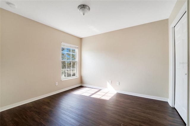 unfurnished bedroom featuring a closet, baseboards, and wood finished floors