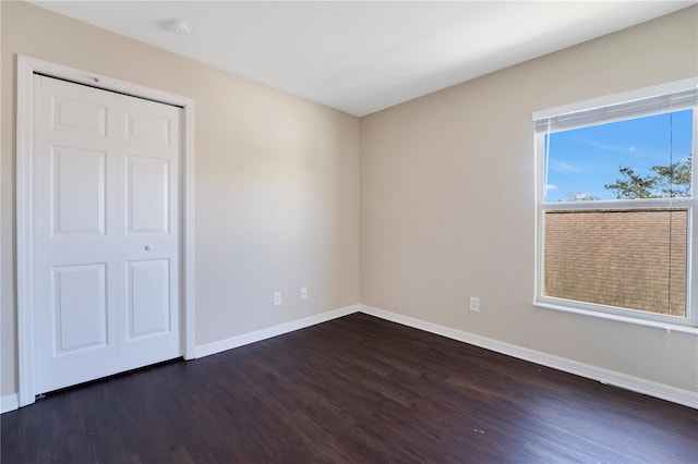 unfurnished bedroom featuring dark wood-type flooring and baseboards