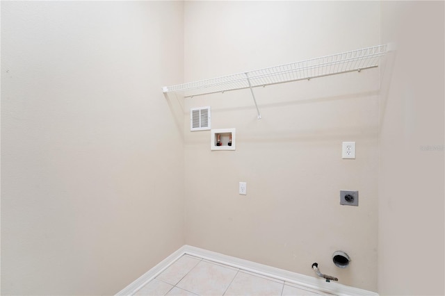 clothes washing area with light tile patterned floors, laundry area, hookup for a gas dryer, hookup for an electric dryer, and washer hookup