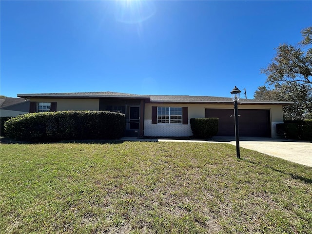 ranch-style home with a garage, a front lawn, concrete driveway, and brick siding