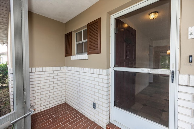 entrance to property featuring brick siding