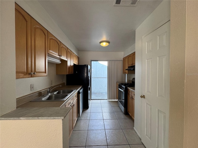 kitchen featuring light tile patterned flooring, a sink, visible vents, light countertops, and appliances with stainless steel finishes