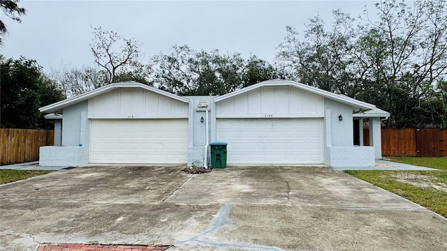 garage with driveway and fence