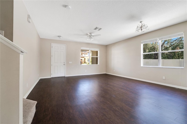 spare room featuring baseboards, visible vents, ceiling fan, dark wood-type flooring, and a textured ceiling