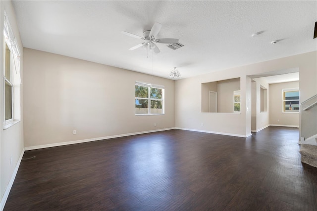 spare room with visible vents, dark wood finished floors, baseboards, ceiling fan, and stairway