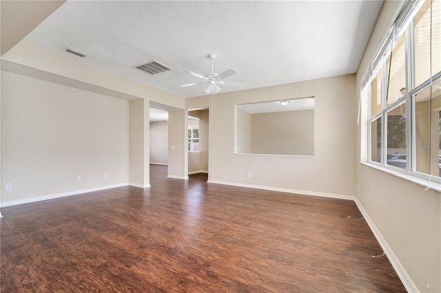 spare room featuring ceiling fan, wood finished floors, and visible vents