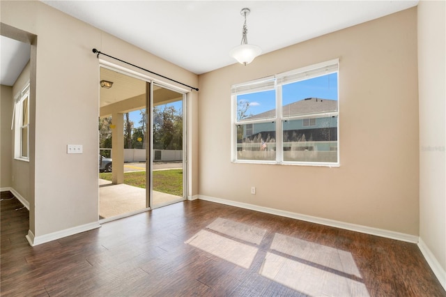 empty room featuring wood finished floors and baseboards