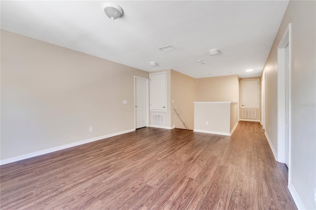 unfurnished room with visible vents, baseboards, and wood finished floors