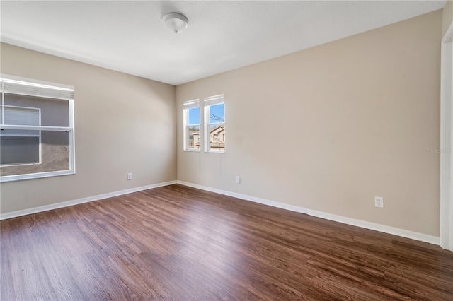 empty room with baseboards and wood finished floors