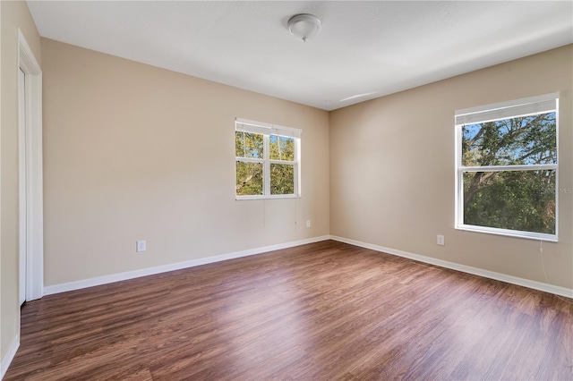 empty room with baseboards and wood finished floors