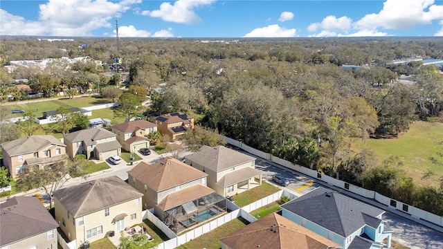 drone / aerial view featuring a residential view and a view of trees