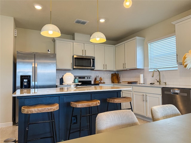 kitchen with visible vents, a sink, stainless steel appliances, light countertops, and white cabinets