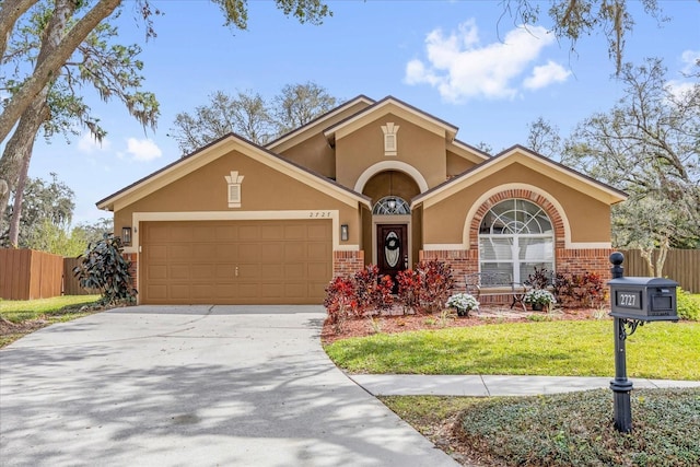 view of front of property with a garage, brick siding, driveway, and stucco siding