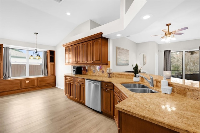 kitchen with a sink, vaulted ceiling, hanging light fixtures, dishwasher, and brown cabinetry